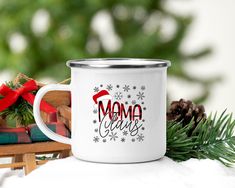 a white coffee mug with the words mama claus on it next to some christmas decorations