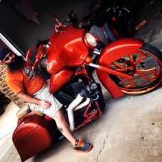 a man sitting on top of a red motorcycle