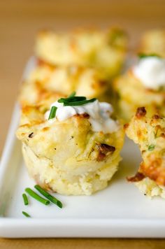 some food is on a white plate with green garnishes and sour cream