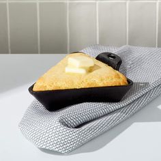 a piece of cake sitting on top of a black and white dish towel next to a knife