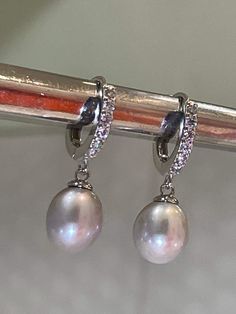 These are the earrings Kate Middleton Wears casually, We replicate them in detail, from pearl shape & size They are made of natural gray Pearl (akoya) with Melee Sized Diamonds Sterling Setting. 925 Stamp setting. Exceptional quality pearl with beautiful luster and brilliant nacre. You can see reflection off the pearl. We also pay attention to detail. Like Kate's earrings... You will also notice there's no hole on the bottom of the pearl, (no posts stick out of bottom like you see on many lo Elegant Silver Akoya Pearl Earrings, Exquisite Silver Dangle Pearl Earrings, Luxury Silver Teardrop Pearl Earrings, Luxury Silver Pearl Drop Earrings, Elegant Silver Diamond Earrings With Pearl Drop, Exquisite Silver Drop Pearl Earrings, Luxury Silver Earrings With Pearl Pendant, Elegant Oval Pearl Earrings With High Luster, Silver Akoya Pearl Dangle Earrings