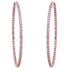 Add a touch of sparkle to your look with these beautiful large inside-out pink sapphire hoop earrings. Expertly crafted in high-quality 14K yellow gold, these earrings feature prong-set round cut pink sapphire, half on the outer hoop and half on the inner hoop, creating a stunning glistening effect. The total pink sapphire weight is 4.39 carats. Earring size: 2 inches. Width: 2.4 mm. Total weight: 11.74 grams. They are securely fastened with a hinged closure. Comes with an appraisal and a presentable gift box. Pink Hoop Earrings, Sapphire Hoop Earrings, Modern Hoop Earrings, Earrings Hoops, Sparkle Earrings, Diamond Hoop Earrings, Sapphire Stone, Modern Earrings, Jewelry Earrings Hoops