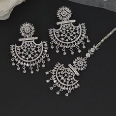 This American Diamond CZ Chandbali  Earrings and Maang Tikka Set are the ultimate in versatile  Indian jewelry. Wear them together or Tikka and Earrings Their own. you can create three different looks with one set.  Earrings drop length is 5.5cm and width 4cm Tikka: L12x3cm This gorgeous pair is made on brass as base metal and handcrafted to perfection with studded white , CZ stones, and Mint Green semi precious stone Droplets. you don't have to opt for the minimalistic all the time. Sometimes it's better to go OTT. Traditional Bridal Sets With Matching Earrings For Wedding, Elegant Dangle Chandbalis For Wedding, Silver Elegant Chandbalis For Wedding, Elegant Silver Chandbalis For Wedding, Silver Chandbalis For Wedding And Festive Occasions, Elegant White Chandbalis For Wedding, Chandbali Bridal Earrings With Intricate Design, Bollywood Style Wedding Jewelry With Matching Earrings, Silver Chandbalis For Diwali Wedding