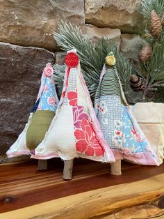 three small christmas trees sitting on top of a wooden table