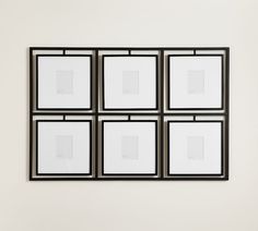 four black and white framed pictures hanging on a wall