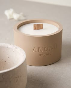 an ommi studio candle sits next to a bowl