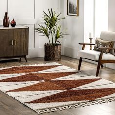 a brown and white rug in a living room next to a wooden cabinet with two vases on it