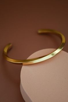 Ultimately simplistic with a unique curved design. This adjustable bangle bracelet is modern and shiny with a gorgeous twisted pattern. Gold dipped and made from a stainless steel metal. Modern Adjustable Bangle With Polished Finish, Adjustable Metal Cuff Bracelet With Polished Finish, Adjustable Stainless Steel Bangle With Polished Finish, Adjustable Bracelet With A Modern Twist, Adjustable Stainless Steel Cuff Bracelet For Formal Occasions, Modern Twist Polished Bangle Cuff Bracelet, Modern Twist Adjustable Bangle As A Gift, Adjustable Bangle With A Modern Twist As A Gift, Polished Stainless Steel Bangle Cuff Bracelet