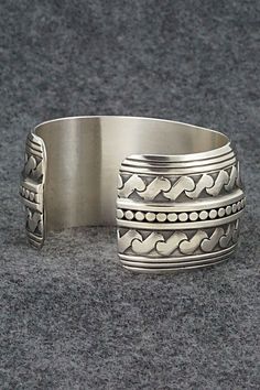 This stunning sterling silver bracelet was made by Navajo silversmith Raymond Delgarito. The back is signed RD and stamped sterling.Size: 5 1/4" (will fit up to a 6 1/4" wrist)Gap: 1"Width: 1 1/4"Free shipping on all orders! We ship with USPS and always include tracking. All orders ship within a day of payment.Returns are accepted up to 30 days after you receive your order. Just send us a message. Our shop offers cash back or store credit. The item must be returned in new condition. Southwestern Sterling Silver Round Cuff Bracelet, Silver Southwestern Style Cuff Bracelet For Formal Occasions, Traditional Nickel-free Sterling Silver Bracelet, Sterling Silver Southwestern Round Cuff Bracelet, Traditional Sterling Silver Nickel-free Bracelet, Bohemian Wide Band Jewelry Stamped 925, Sterling Silver Cuff Bracelet With Intricate Design, Adjustable Silver Southwestern Bracelet, Southwestern Engraved Sterling Silver Bracelet Gift