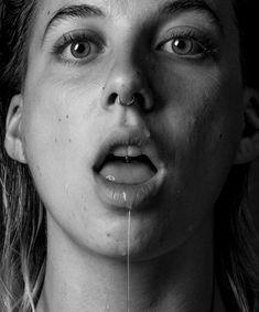 black and white photograph of a woman's face with water dripping from her mouth