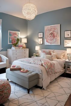 a bedroom with blue walls, white furniture and pink flowers on the wall above the bed