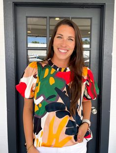 Colorful print top with a frilled neck, back yoke and shirring detail, short puffed sleeves, smocked cuffs.- Unlined, sheer, lightweight. Chelsea is wearing a size Large. Height is 5’8, Bust is 36”, Waist 28” - 29”, and Hips 42”. Trendy Multicolor Flutter Sleeve Tops, Multicolor Blouse With Gathered Sleeves, Chic Multicolor Flutter Sleeve Top, Casual Multicolor Flutter Sleeve Blouse, Trendy Multicolor Flutter Sleeve Blouse, Trendy Multicolor Blouse With Flutter Sleeves, Trendy Short Sleeve Blouse With Smocked Back, Spring Multicolor Puff Sleeve Top, Short Sleeve Blouse With Gathered Sleeves For Brunch