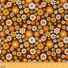 an orange and white flower pattern on brown fabric with yellow, white, and red flowers