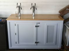 two faucets sitting on top of a white cabinet