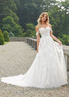 a woman in a wedding dress standing on a bridge