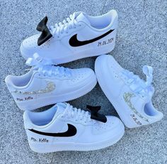 three white nike air force sneakers with black and gold sequins on the side