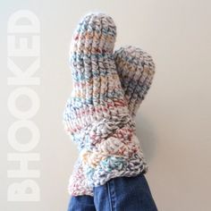 a person's hand wearing a knitted mitten on top of their head