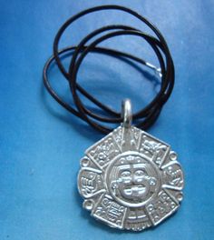 "AZTEC CALENDAR TONATIUH GOD SUN Silver Aztec calendar pendant that symbolizes the center of the sun stone. In this silver Aztec calendar pendant a fragment of the so-called sun stone has been taken representing Tonatiuh the Aztec sun god sterling Silver pendant 925 Dimensions calendar: 3.4 diameter PROVENANCE of the god TONATIUH (for the Aztec calendar pendant silver) Aztec civilization. Mexica people. Precolumbian era. Tonatiuh's disk is the central fragment that is part of the sun stone. A ba Silver Medallion Necklace Amulet Style, Spiritual Sun And Moon Design Jewelry, Aztec Sun Stone Tattoo, Sterling Silver Amulet Medallion Necklace, Silver Medallion Necklace With Sun Design, Silver Bohemian Necklace With Sun Design, Symbolic Silver Necklace With Sun Design, Aztec Sun God, Spiritual Silver Necklace With Sun Design