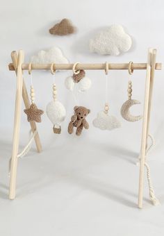 a baby crib with stuffed animals hanging from it's sides and clouds in the background