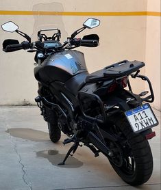 a black motorcycle parked in front of a building with its license plate on it's side