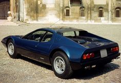 a blue sports car parked in front of a building