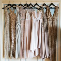 there are many different dresses hanging on the rack in front of each other, and one is gold