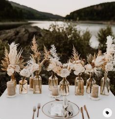 there are many vases with flowers in them on the table