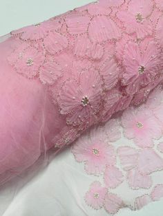 the pink fabric is covered with sequins and beads