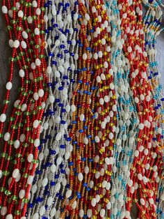 many different colored beads are hanging on the wall