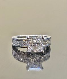 a princess cut diamond ring with channeled sidestones