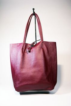 A lightweight and spacious Leather Shopper Tote Bag-Burgundy you can use for your office, gym and after-hours essentials while still looking stylish. Handmade from supple calfskin leather, the versatile look features over-the-shoulder handles and minimal detailing. Raw edges and no lining makes this style super light and easy to fold when traveling. Inside is a zippered document pouch and a leather cell phone pouch. Details: Color: BurgundyTwo leather strap for closing the bag.Natural unlined in Burgundy Satchel Shoulder Bag With Leather Lining, Casual Burgundy Bags For Daily Use, Red Leather Handle Shoulder Bag For Business, Red Leather Handles Shoulder Bag For Business, Burgundy Satchel With Leather Lining, Burgundy Satchel For Everyday Use, Burgundy Shoulder Bag For Daily Use, Chic Burgundy Hobo Bag For Everyday, Chic Everyday Burgundy Hobo Bag