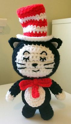 a crocheted cat with a red and white hat