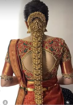 the back of a woman's blouse with intricate gold and red designs on it