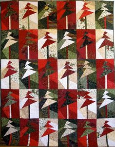 a red and green quilt with white triangles on it