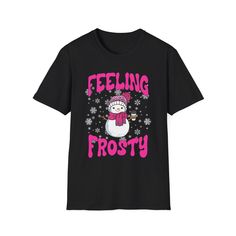 This t-shirt gives off a cozy and festive vibe, perfect for the holiday season. It is relevant to women who love Christmas and enjoy whimsical designs on clothing. PRODUCT DESCRIPTION: Soft and lightweight: Made from 100% ring-spun cotton for a comfortable feel Durable and high-quality fabric: 4.5 oz (153 g/m²) weight ensures a sturdy yet breathable t-shirt Unisex fit: Designed to suit both men and women with a modern, flattering cut Pre-shrunk: Won't shrink in the wash, maintaining its original Black T-shirt With Character Print For Winter, Cheap Festive Winter T-shirt, Snowman T Shirt Ideas, Snowmen Tshirts, Frosty The Snowman Tshirt, Coffee Lovers Gift, Snowman Design, Christmas Graphic, Winter Shirts