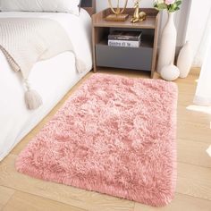 a pink rug on the floor in a bedroom