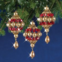 two christmas ornaments hanging from a tree with red and gold beads on it's sides