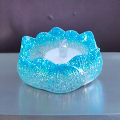 a blue candle holder sitting on top of a table