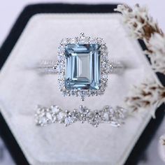 an engagement ring and wedding band set in white gold with blue topaz surrounded by diamonds