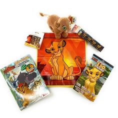 the lion king stuffed animal is surrounded by books and crayon pencils on a white background