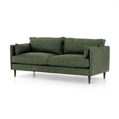 a green couch with two pillows on the back and one arm folded up to show it's shape