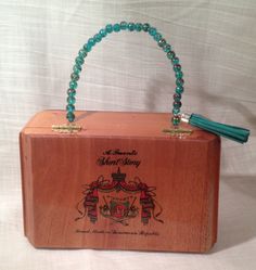 a wooden box with beads and a tassel on it's handle is shown