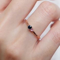 a woman's hand with a ring on it and two stones in the middle