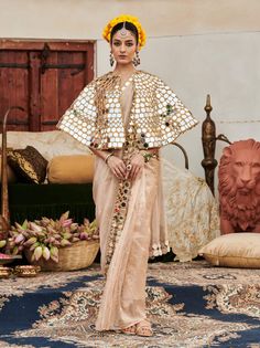 A sophisticated ensemble, this beige sari features a stunning mirror work border that adds an elegant touch. Styled with a full mirror work cape, this outfit beautifully merges traditional charm with modern glamour, making it a perfect choice for special occasions and celebrations. Traditional Wear With Dupatta And Cape Sleeves For Festivals, Navratri Dupatta With Cutdana And Cape Sleeves, Cape Sleeves Anarkali Set With Cutdana For Eid, Anarkali Choli With Cape Sleeves For Festivals, Traditional Wear With Resham Embroidery And Cape Sleeves, Diwali Lehenga With Cape Sleeves And Cutdana, Diwali Lehenga With Cutdana And Cape Sleeves, Traditional Sharara With Gota Work And Cape Sleeves, Bollywood Style Choli With Cape Sleeves And Cutdana