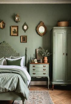 a bedroom with green walls and pictures on the wall above the bed, along with an antique dresser