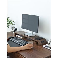 a person is sitting at a desk with a computer and drink in front of them