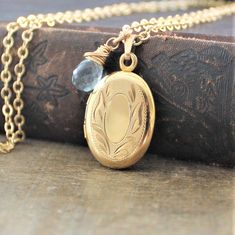 "A lovely gold filled locket graces this necklace. The vintage piece has classic swirled etched on the front; the back is plain. The 12k gold filled pendant is hallmarked on the inside which has two frames to place your beloved photos beneath. The locket has been set on a new 14k gold filled chain and paired with a wire wrapped aquamarine briolette (March birthstone). The necklace is finished with a lobster clasp. Locket 26x17mm Necklace 18\" (45cm) ✦All of our vintage lockets ship with complime Locket Picture, Locket Gold, Push Presents, Gold Locket Necklace, Push Present, Picture Locket, Oval Locket, Vintage Lockets, Aquamarine Necklace