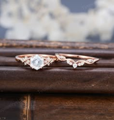 two wedding rings sitting on top of a wooden table