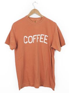 This Wavy Coffee design T-shirt is the perfect little pick-me-up! It's printed on the comfiest Comfort Colors tee, with the perfect vintage look. True to size or size up to rock the oversized look. A total must-have for any true coffee connoisseur! You can select the size and shirt color and we will make this shirt just for you. Since this shirt is made just for you please allow 2-3 weeks for your order to ship out. Casual Coffee-colored Screen Print T-shirt, Coffee Color Crew Neck T-shirt For Everyday, Coffee Colored Relaxed Fit T-shirt With Slogan, Retro T-shirt For Everyday Fall Wear, Vintage Slogan T-shirt For Fall, Vintage Acid Wash Tops For Everyday Wear, Coffee Color Short Sleeve T-shirt With Screen Print, Brown Graphic Tee With Text Print, Retro Pre-shrunk T-shirt For Everyday