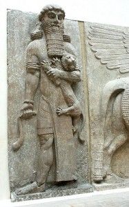 an ancient sculpture is displayed on the wall in front of a man holding a baby